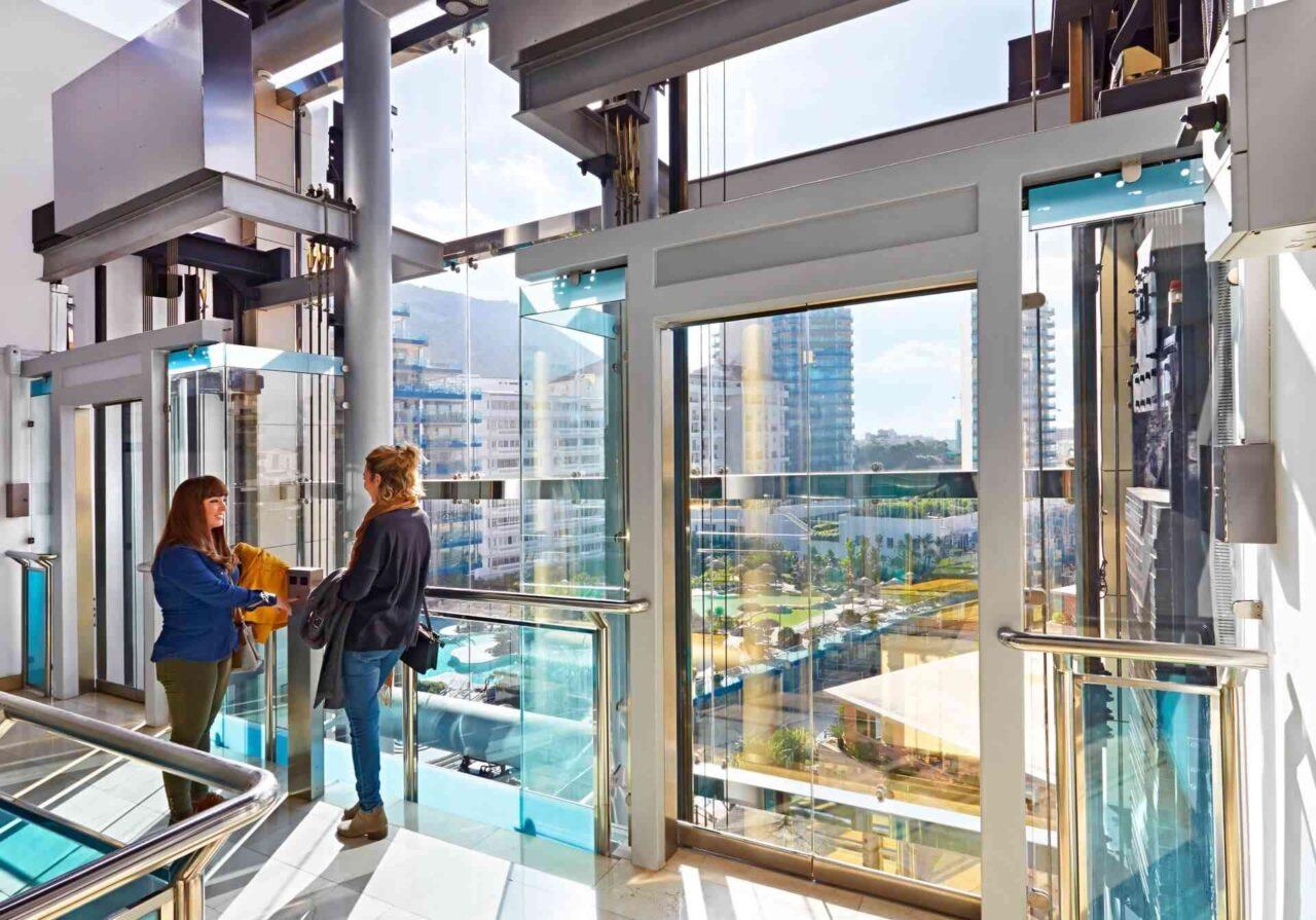 Two persons standing next to an elevator FAIN, Ocean Village Gibraltar