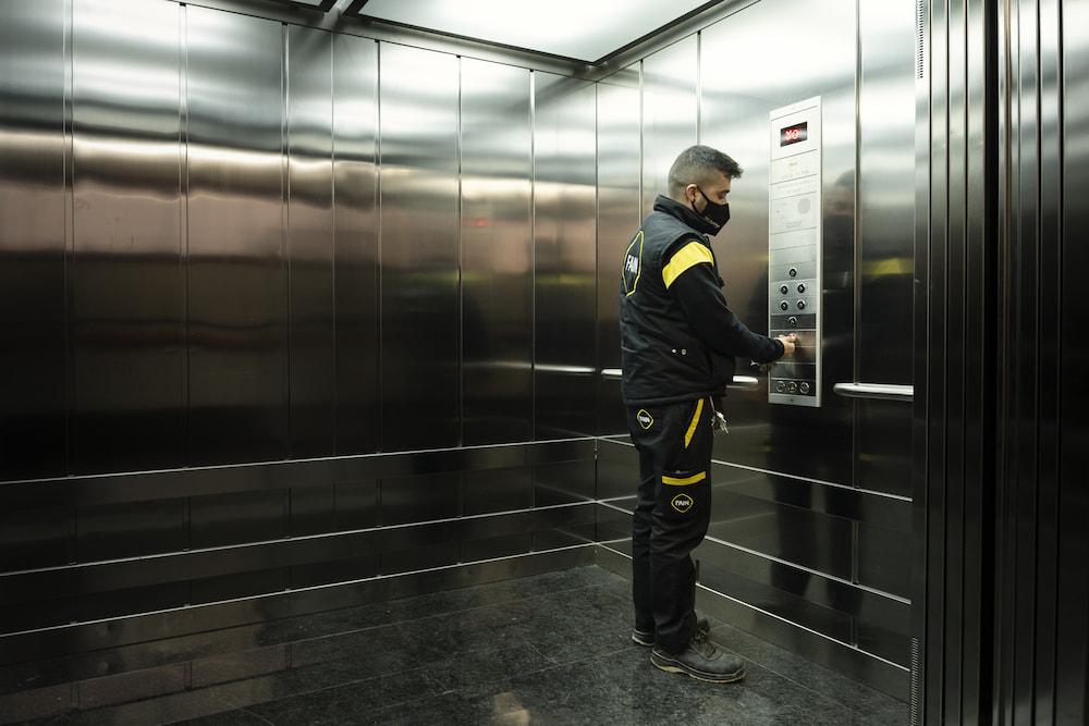 FAIN technician touching a lift emergency button