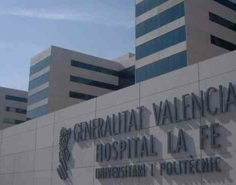 Facade of Hospital La Fe in Valencia with the name and modern buildings behind.