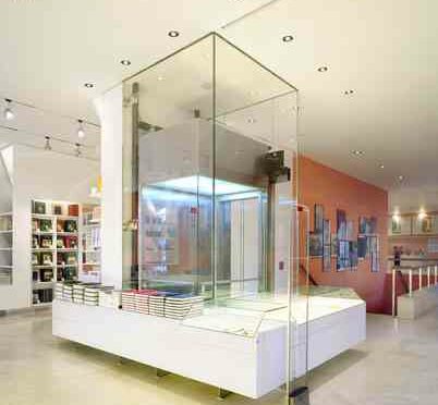 Interior of a sleek store with a central glass display case surrounded by shelves.